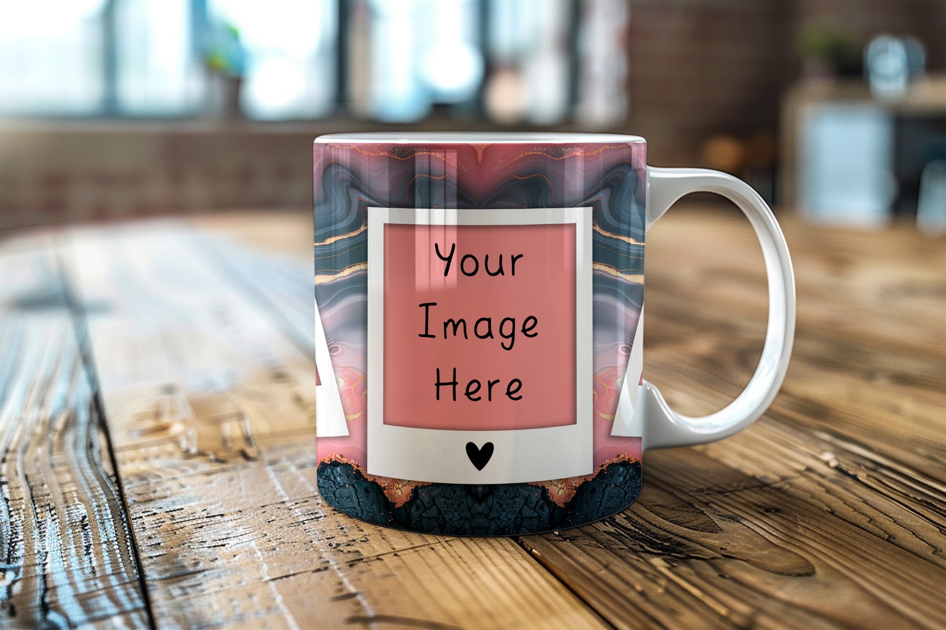 A custom printed ceramic mug with a pink and gray marbled pattern, featuring a white Polaroid-style frame graphic with the text 'Your Image Here' and a small black heart. The mug is shown on a rustic wooden table with a blurred indoor background.