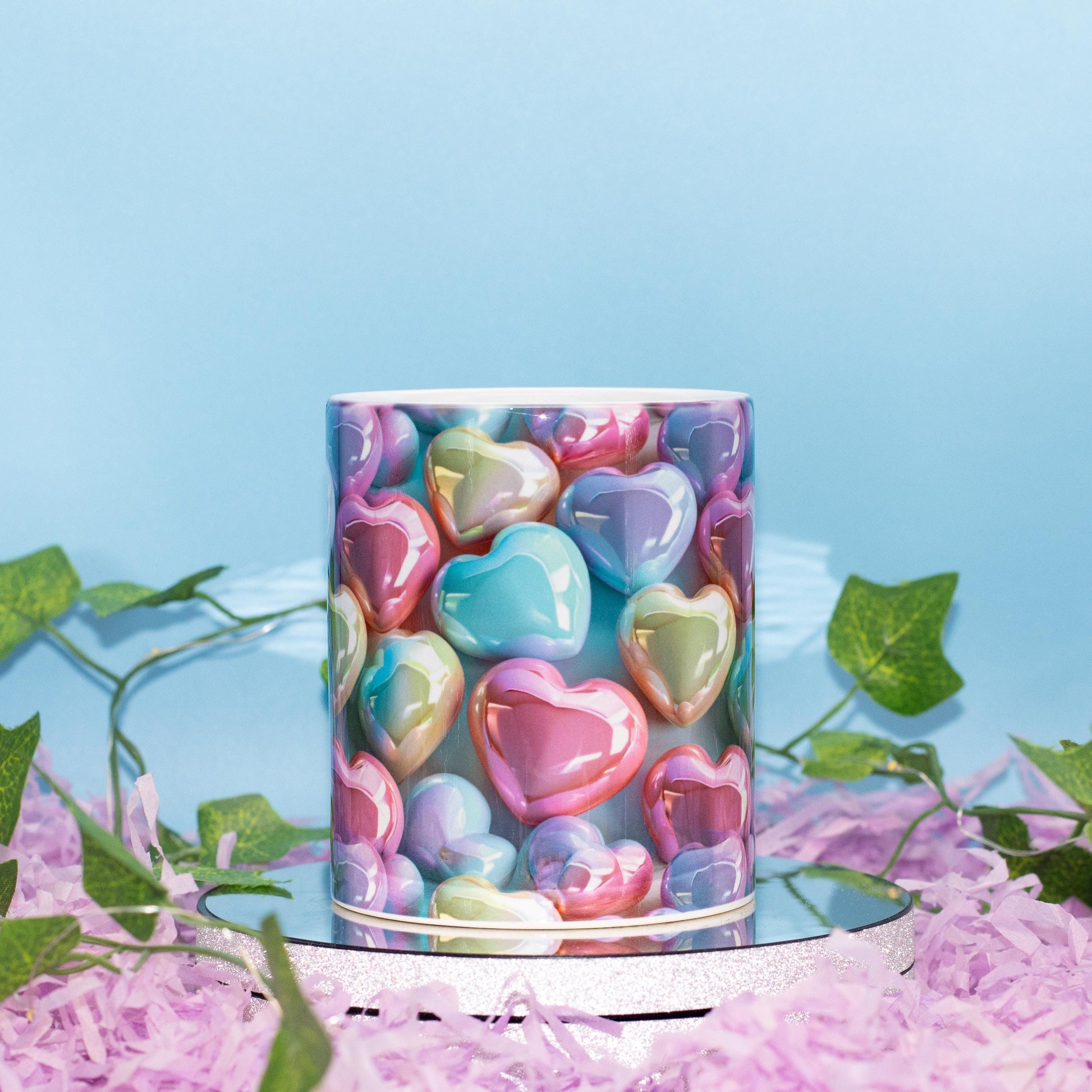A ceramic mug with a colorful print of glossy, pastel heart-shaped candies