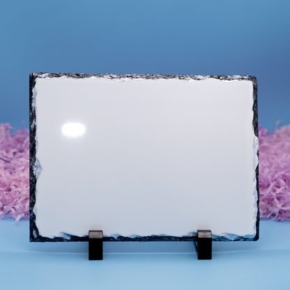 A rectangular plaque with a rough dark natural border, displayed on two small black stands against a blue background with pink decorative filler on the sides.