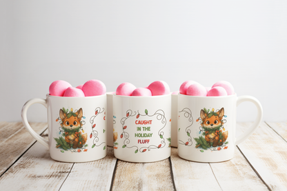 Three white ceramic mugs with holiday fox illustrations arranged on a rustic wooden surface against a light gray background.