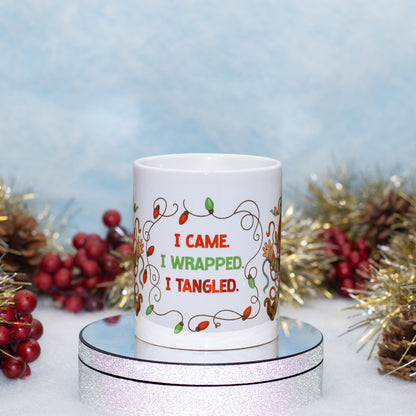 A white ceramic mug with a Christmas-themed graphic reading 'I CAME. I WRAPPED.