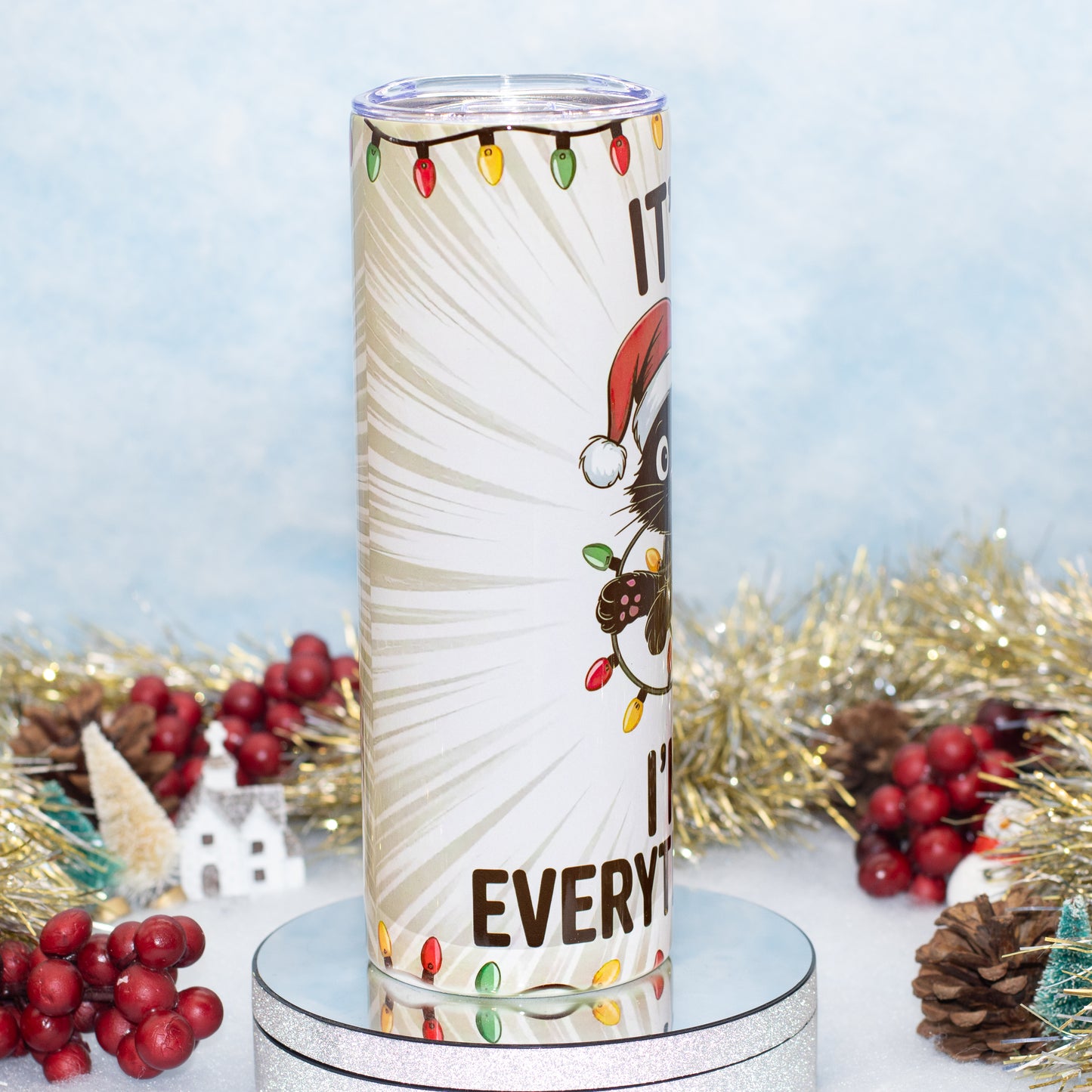 A tall insulated tumbler with a festive Christmas design, featuring a cartoon Cat in a Santa hat on a light blue background with holiday decorations.