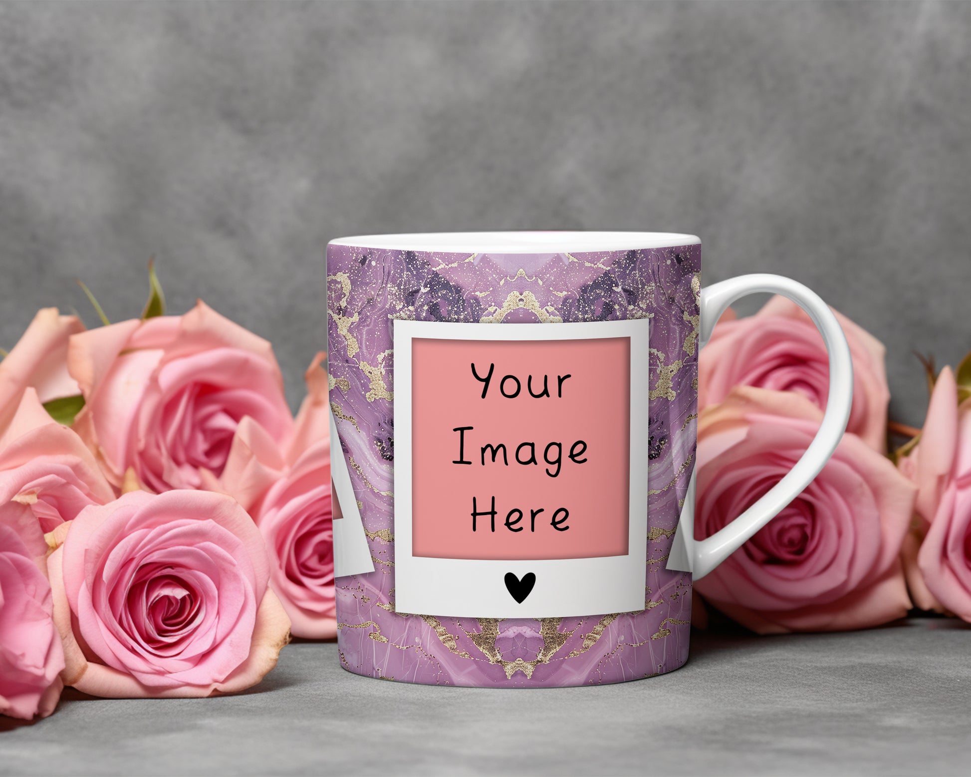 A customizable ceramic mug with a purple and gold marble pattern, featuring a pink placeholder label that reads 'Your Image Here' with a small black heart. The mug is styled with pink roses on a gray surface against a textured gray background.