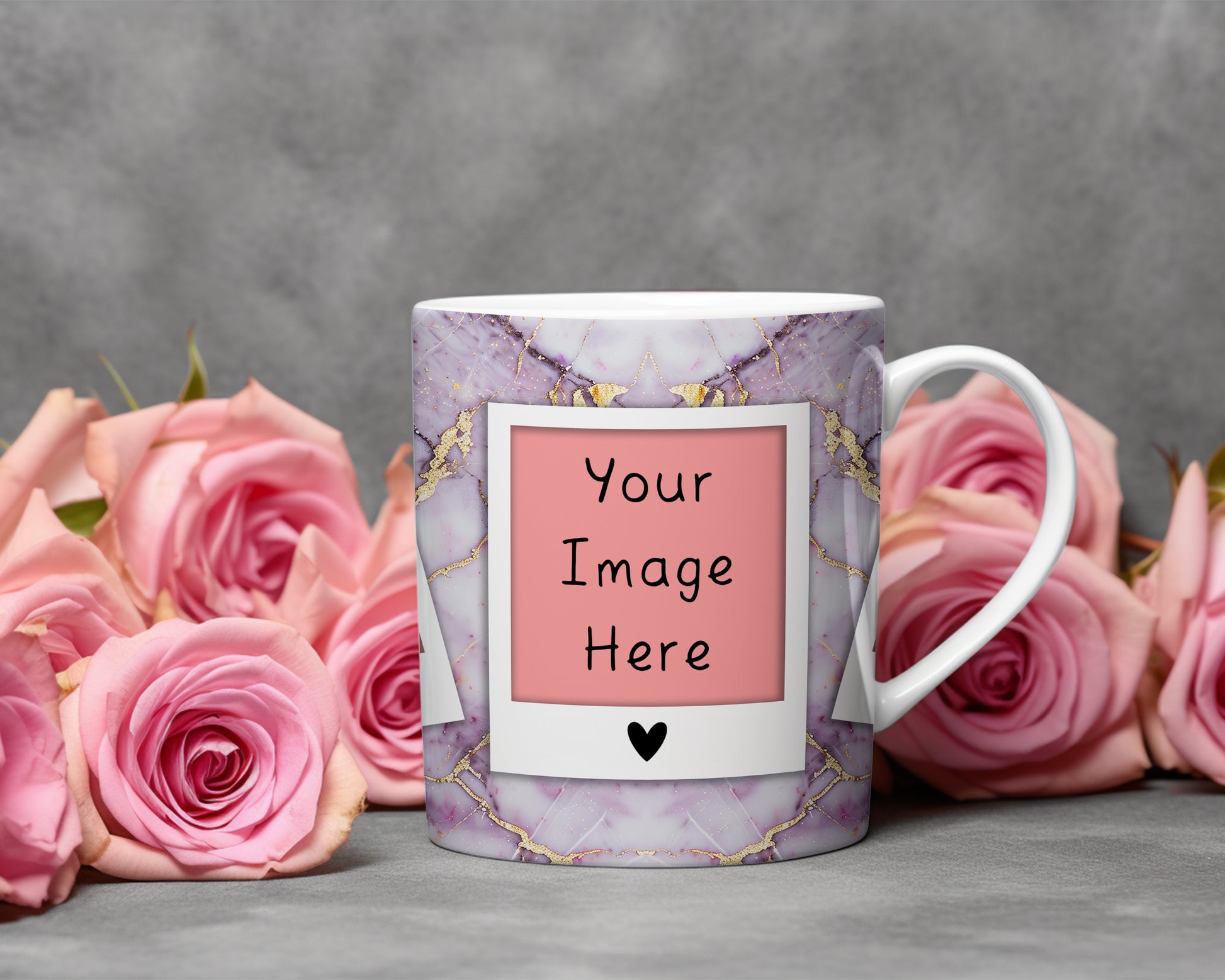 A white ceramic mug with a purple and gold marble pattern, featuring a customizable pink photo frame design with the text 'Your Image Here' and a small black heart. The mug is styled on a gray surface surrounded by pink roses against a textured gray background.
