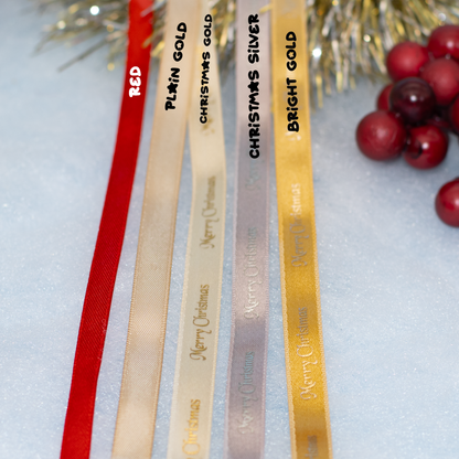 Five Christmas ribbon color options are shown in a close-up: red, plain gold, Christmas gold, Christmas silver, and bright gold, with festive tinsel and red berries as props on a light background.