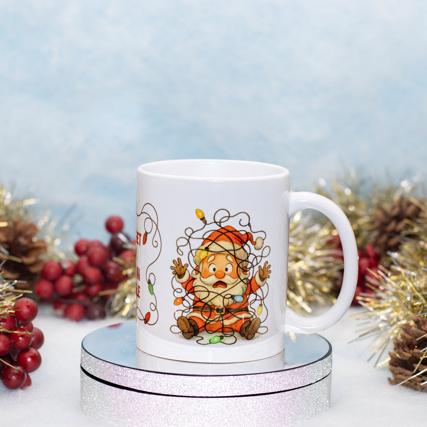 A ceramic mug featuring a cartoon Santa wrapped in tinsel 