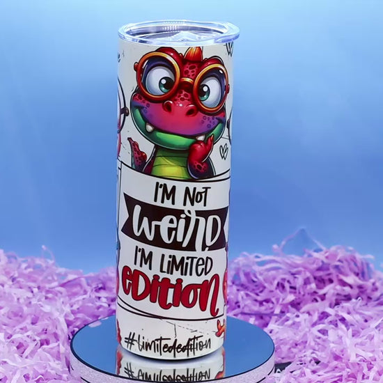 Video Showcasing A cylindrical tumbler with a colourful cartoon dino graphic and the text 'I'M Not weird I'M Limited Edition'