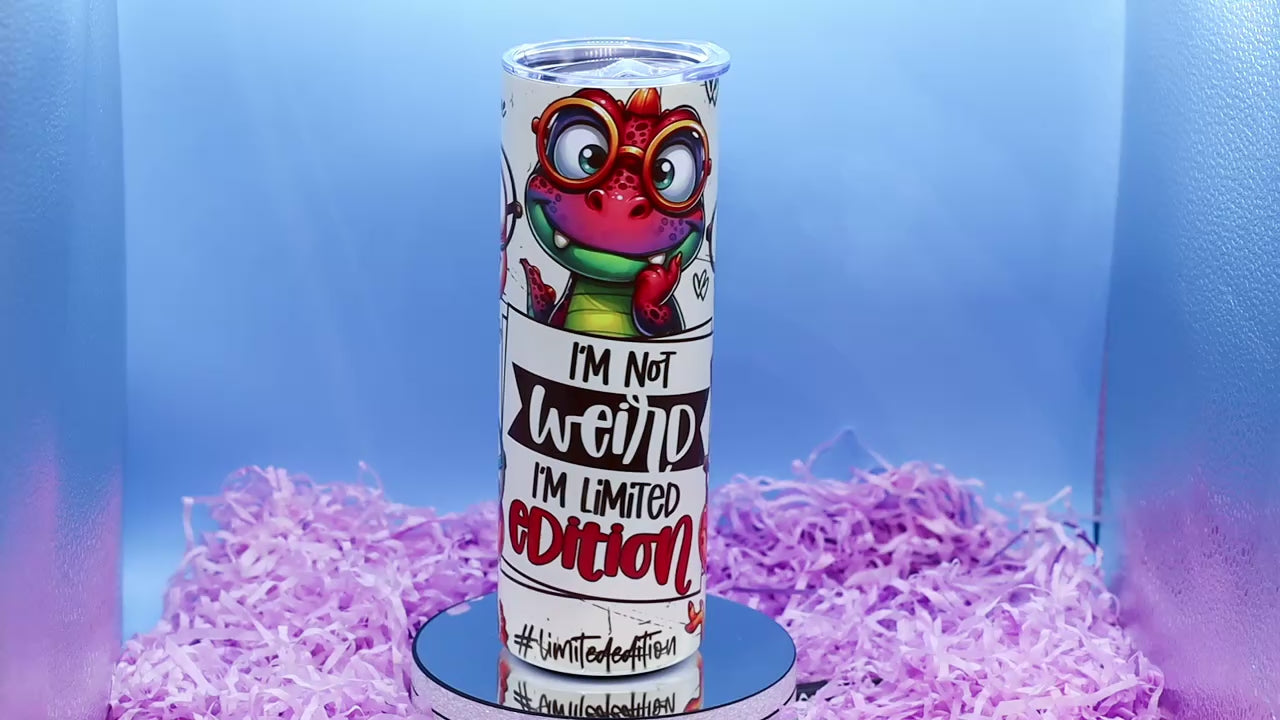 Video Showcasing A cylindrical tumbler with a colourful cartoon dino graphic and the text 'I'M Not weird I'M Limited Edition'