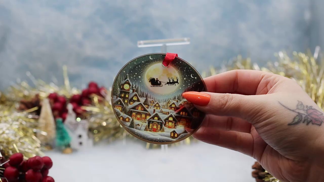 Video showcasing a glass frosted Christmas ornament featuring a Santa slay over a snowy town