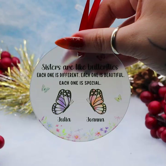 Video Showcasing a frost glass ornament with this inscription of Sisters are like butterflied, Each one is different, each one is beautiful, each one is special