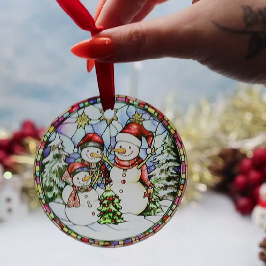 Video showcasing a frosted glass Christmas ornament featuring a winter scene with a snowman family