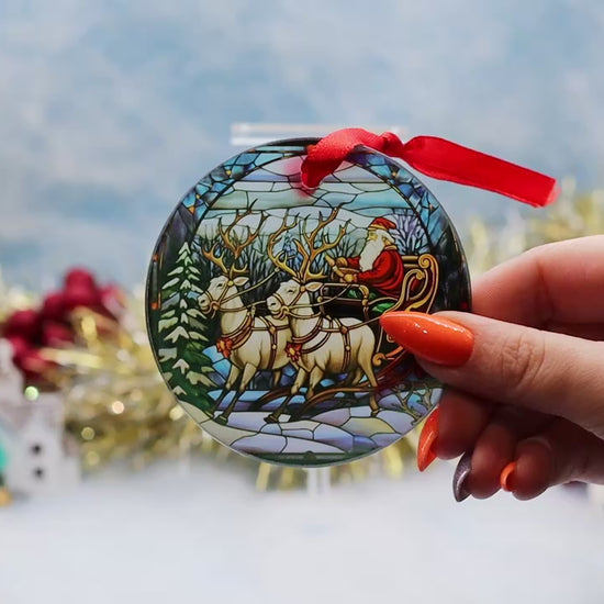 Video showcasing a frosted glass Christmas ornament showcasing a Santa sled scene