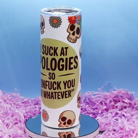 Video Showcasing A white insulated tumbler with a humorous skeleton graphic and text reading 'I SUCK APOLOGIES SO "UNFUCK YOURSELF OR WHATEVER"',