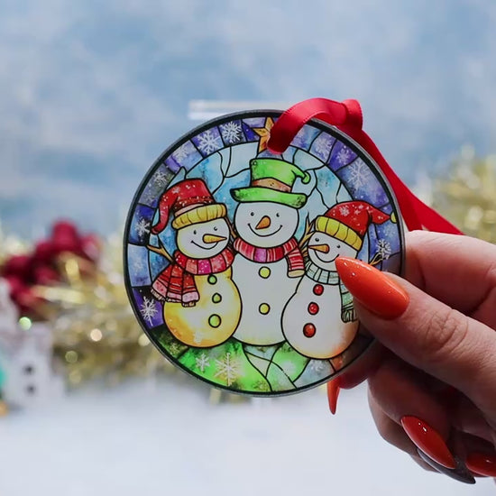 Video showcasing a frosted glass Christmas ornament featuring 2 snowman's on a stainless window image. 
