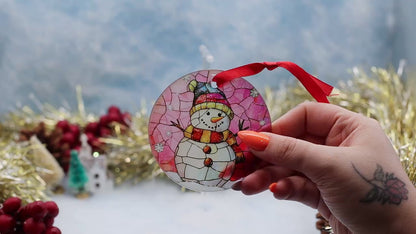 Video showcasing a frosted glass Christmas ornament featuring a snowman on a stain glassed effect image