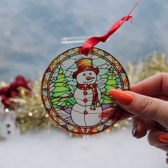 Video showcasing a frosted glass Christmas ornament featuring a stain glass theme illustration with a jolly snowman
