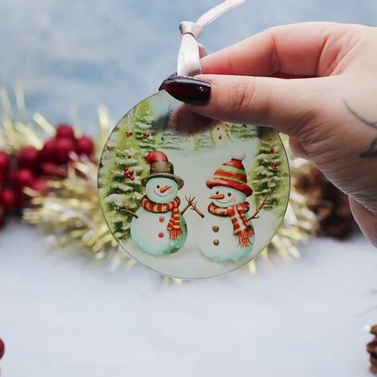 Video showcasing a frosted glass Christmas ornament showcasing a fun snowman scene