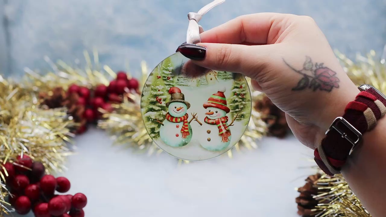 Video showcasing a frosted glass Christmas ornament showcasing a fun snowman scene