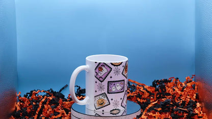 Video showcasing A white ceramic mug with a Halloween-themed pattern of candy corn, ghosts, and jack-o'-lanterns on a light pink background,
