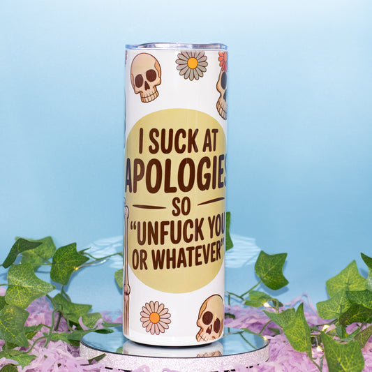 A white insulated tumbler with a humorous message printed on it, styled with decorative green ivy and purple flowers on a light blue background.